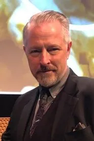 Foto de Bryan Moore interpretando a DJ Voice (voice) en Whispers from a Shallow Grave